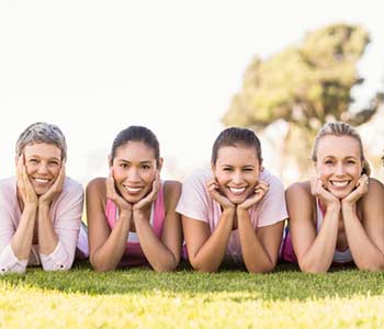 Smiling women lying in a row and wearing pink